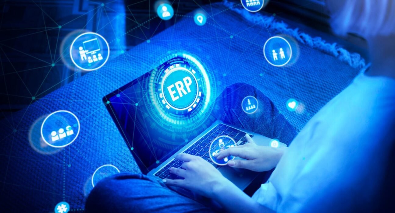 find more africa #findmoreafrica › Futuristic scene of a person typing on a laptop with a glowing ERP hub at the center, surrounded by digital icons.