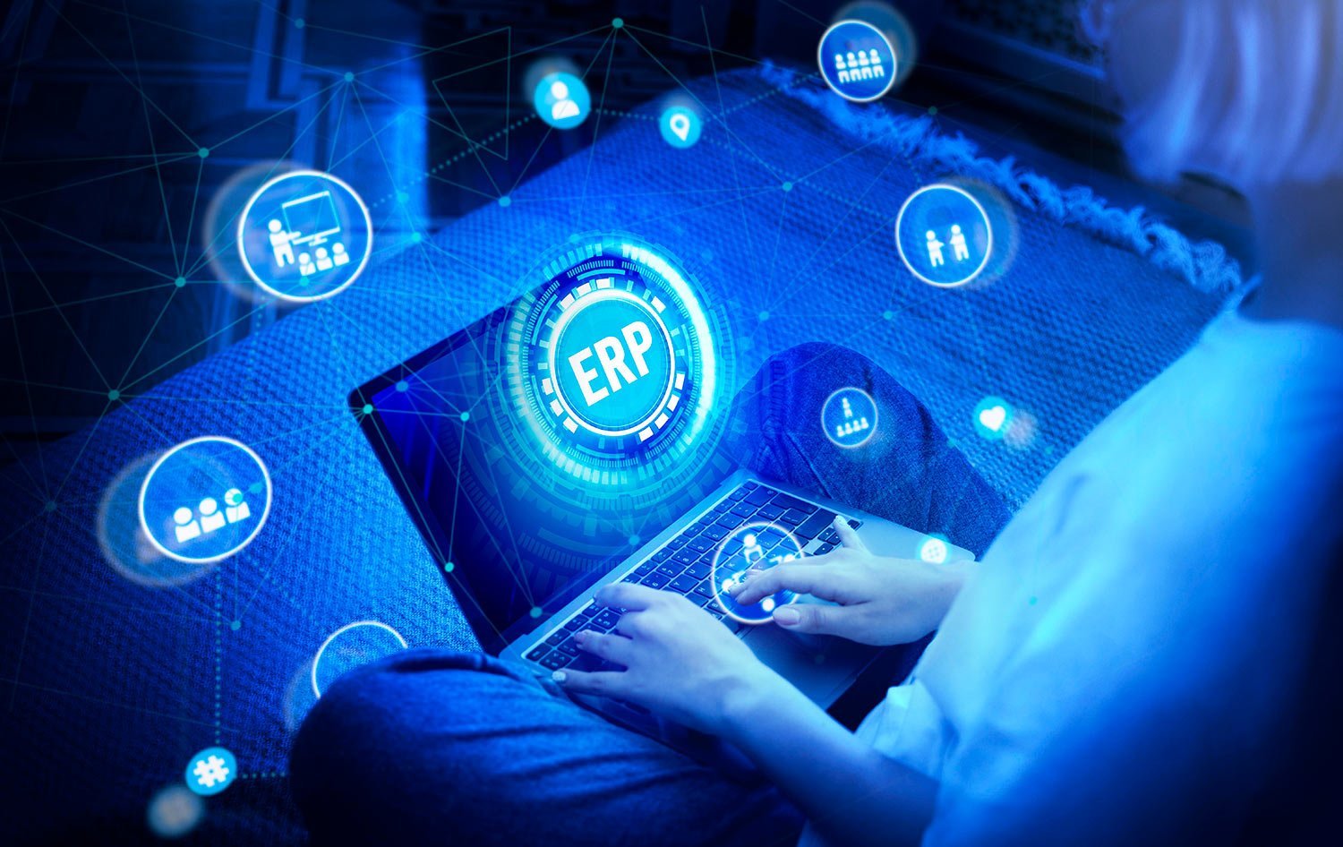 Futuristic scene of a person typing on a laptop with a glowing ERP hub at the center, surrounded by digital icons.