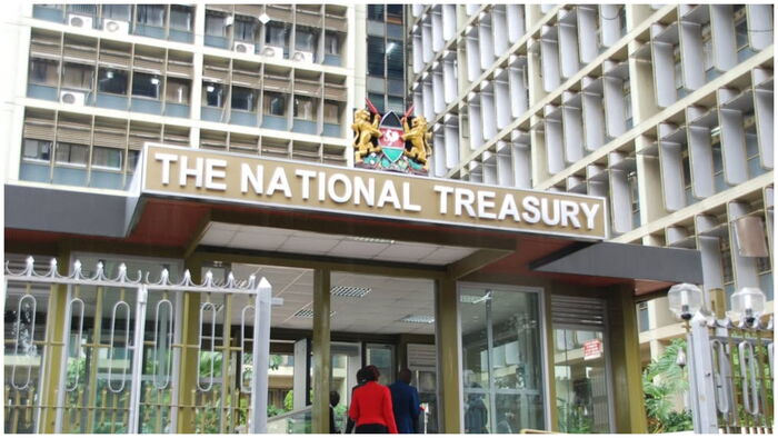 find more africa #findmoreafrica › Front entrance of The National Treasury building with its name on a sign and a crest above, two people entering.