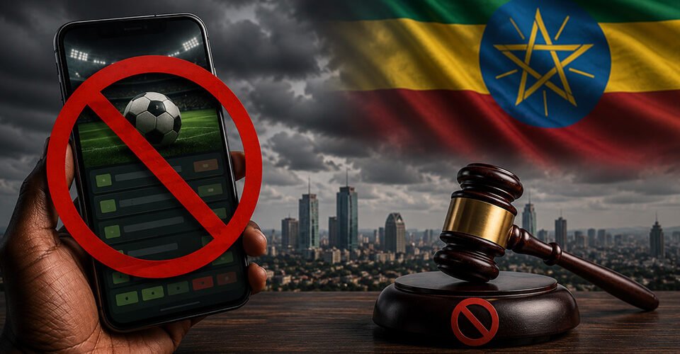 No mobile sports betting in Ethiopia: phone screen shows a soccer app with a red prohibition symbol, a judge's gavel nearby, and the Ethiopian flag in the background.