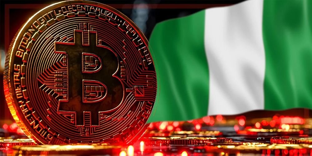 Close-up of a Bitcoin coin on a reflective surface, with the Nigerian flag blurred in the background.