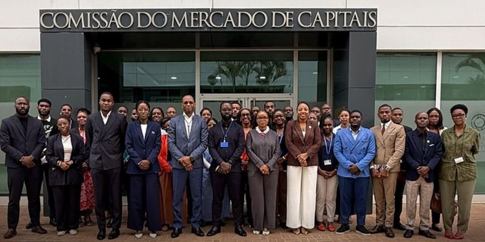 Diverse group of professionals posing for a formal group photo outside a building labeled 'Comissão do Mercado de Capitais'.