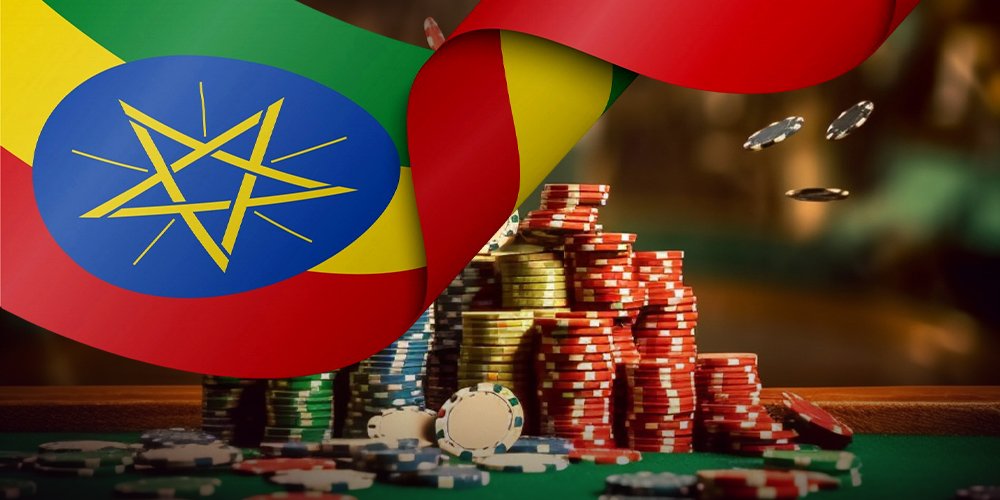 Stacks of poker chips and scattered coins on a green casino table, with an Ethiopian flag draped over the surface in the background.