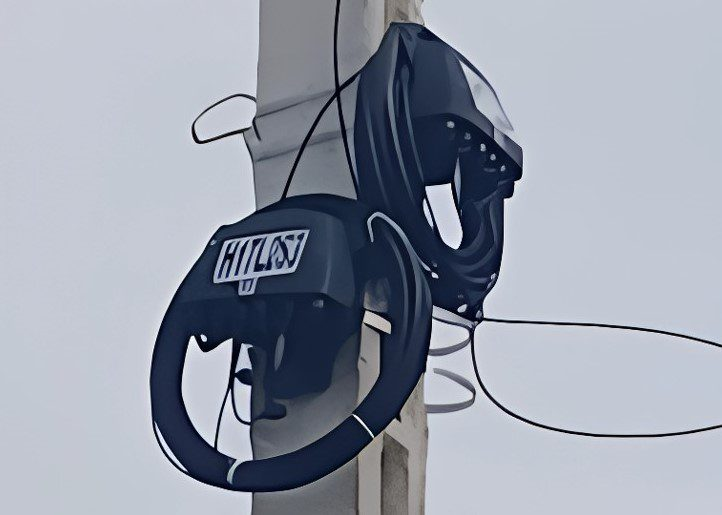 Hilti-branded safety reel mounted on a wooden utility pole with a black circular housing and coiled cable.