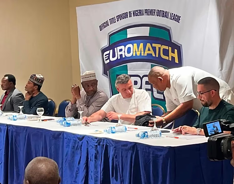 Panel of men seated at a long table with water bottles, in front of a large Euromatch banner (Nigeria Premier League sponsor)